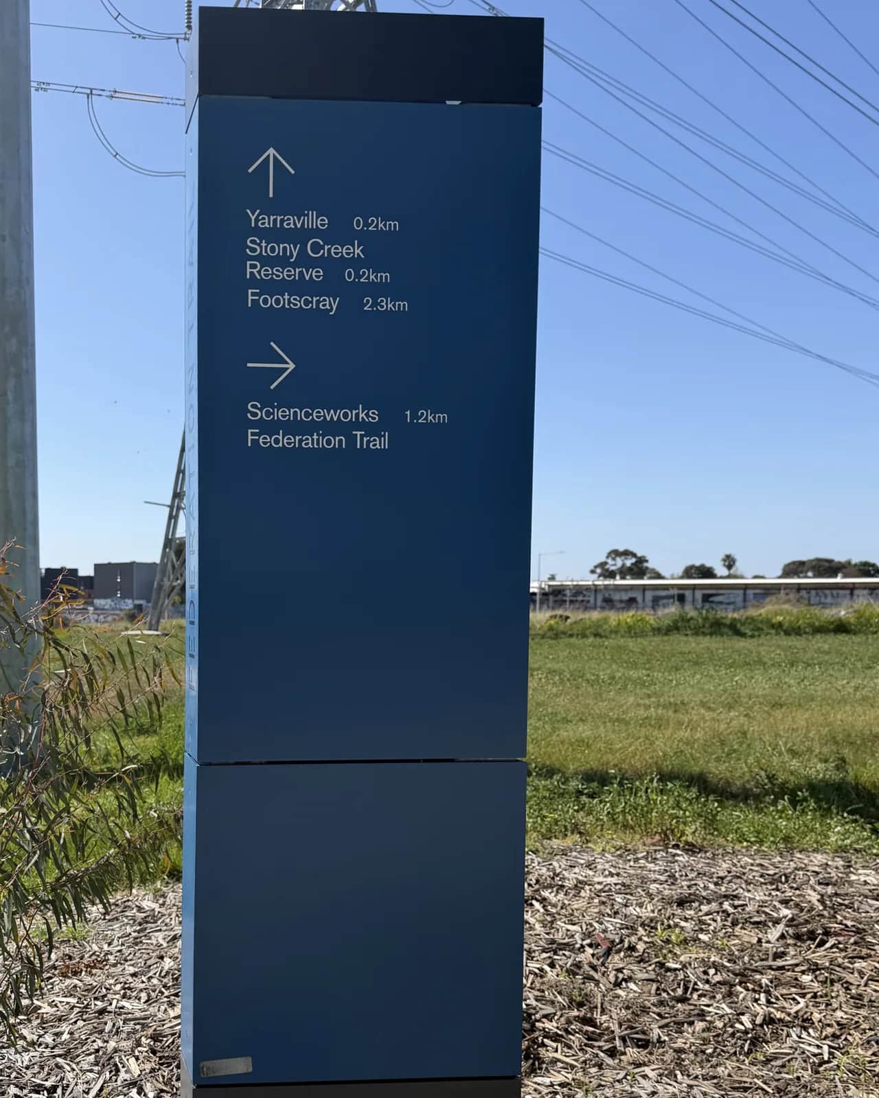 The same wayfinding sign, clean, with its directions readable